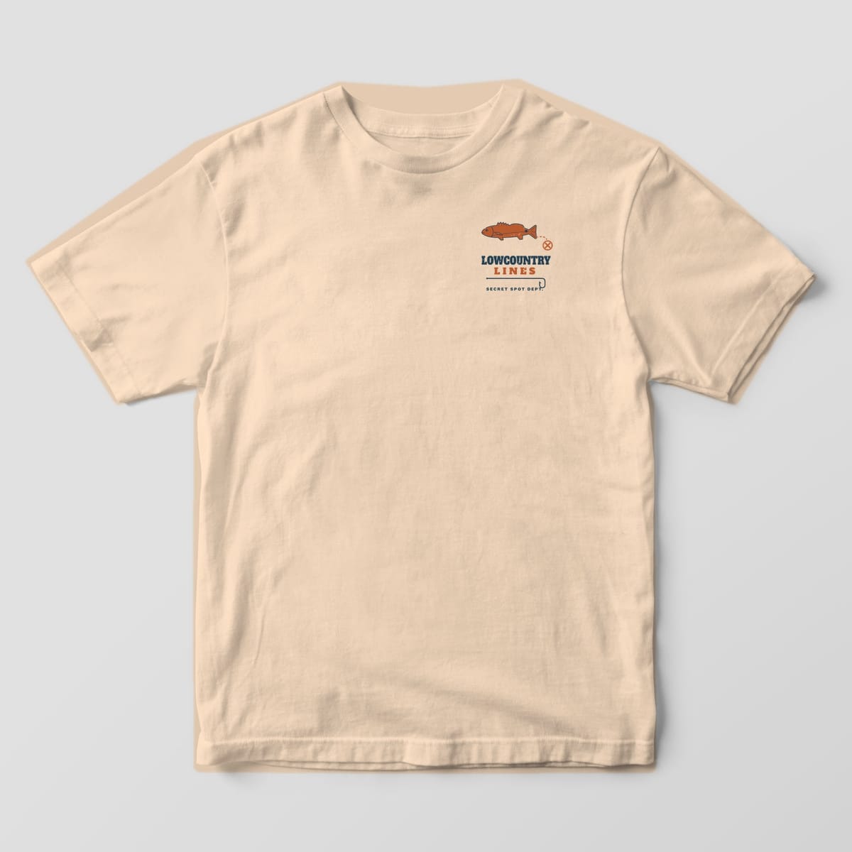Ivory Comfort Colors tee, front view, with a small copper redfish, an X mark and Lowcountry Lines wordmark