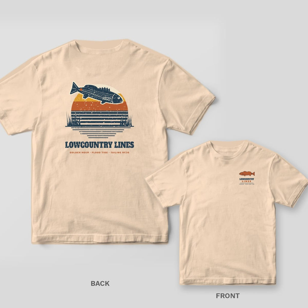 Back and front of an ivory T-shirt: back shows a navy redfish leaping over a retro striped sunset; front has a small copper redfish logo