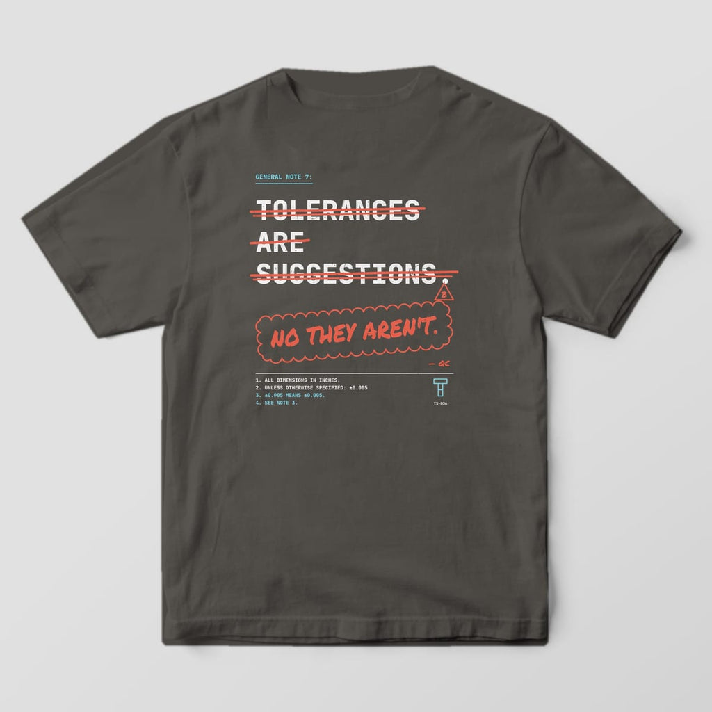 Back of a Pepper Comfort Colors 1717 tee: off-white mono words Tolerances Are Suggestions struck through in red marker, with No They Aren't in a red revision cloud.