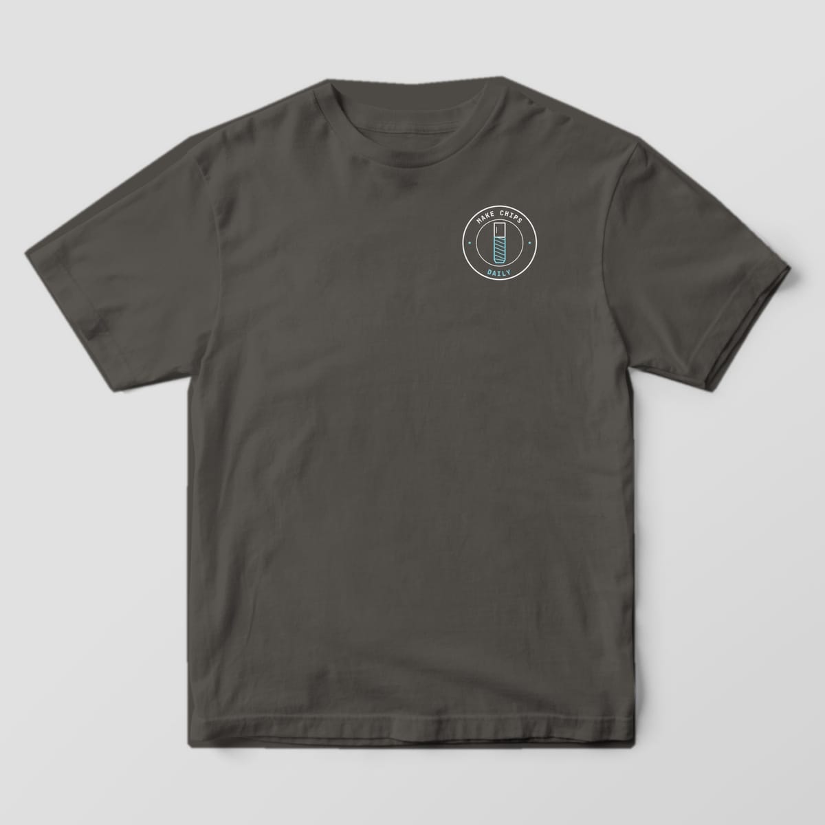 Front of a Pepper Comfort Colors 1717 tee with a small round Make Chips Daily end mill badge on the left chest.