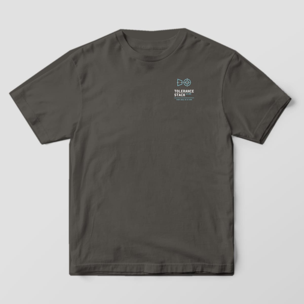 Front of a Pepper Comfort Colors 1717 tee with a small left-chest third-angle projection symbol above the words Tolerance Stack.