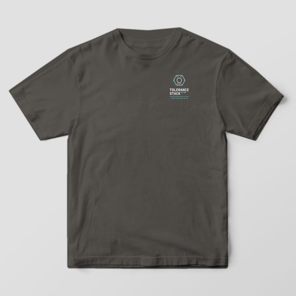 Front of a Pepper Comfort Colors 1717 tee with a small left-chest hex nut reading Est. at Nominal above the words Tolerance Stack.