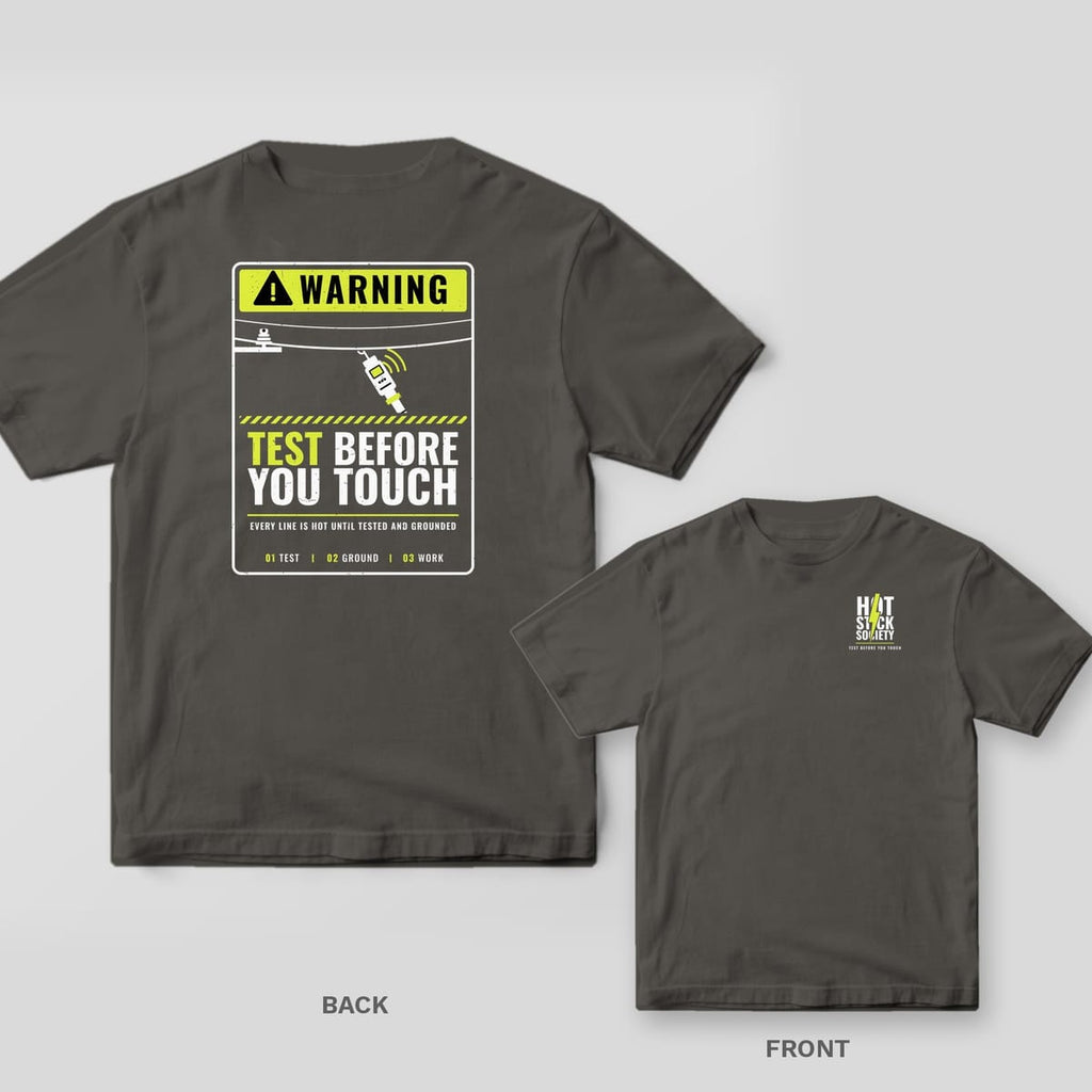 Back and front of a pepper Test Before You Touch warning-sign lineman T-shirt shown together, back print large on the left and the small chest print on the right