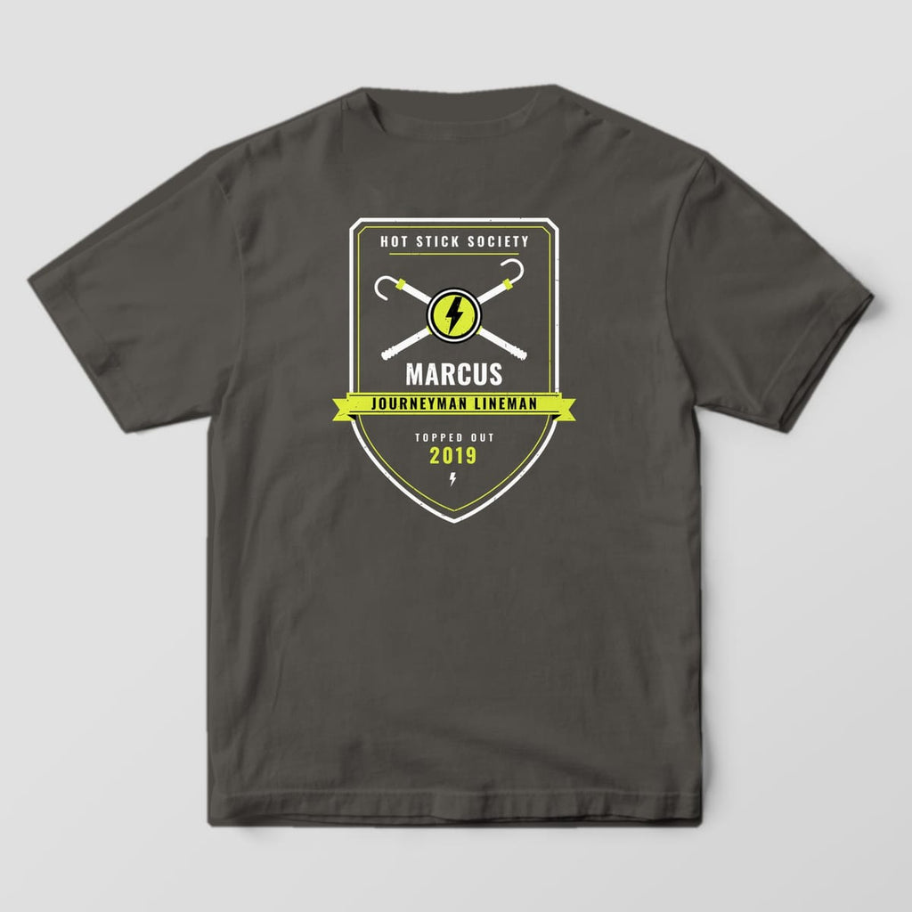 Back view of the pepper Comfort Colors 1717 shirt showing the personalized Journeyman Lineman crew badge back print in hi-vis yellow and white