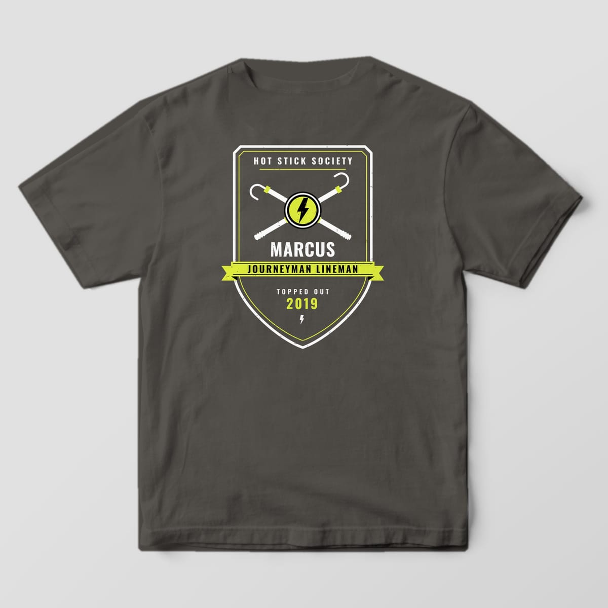 Back view of the pepper Comfort Colors 1717 shirt showing the personalized Journeyman Lineman crew badge back print in hi-vis yellow and white