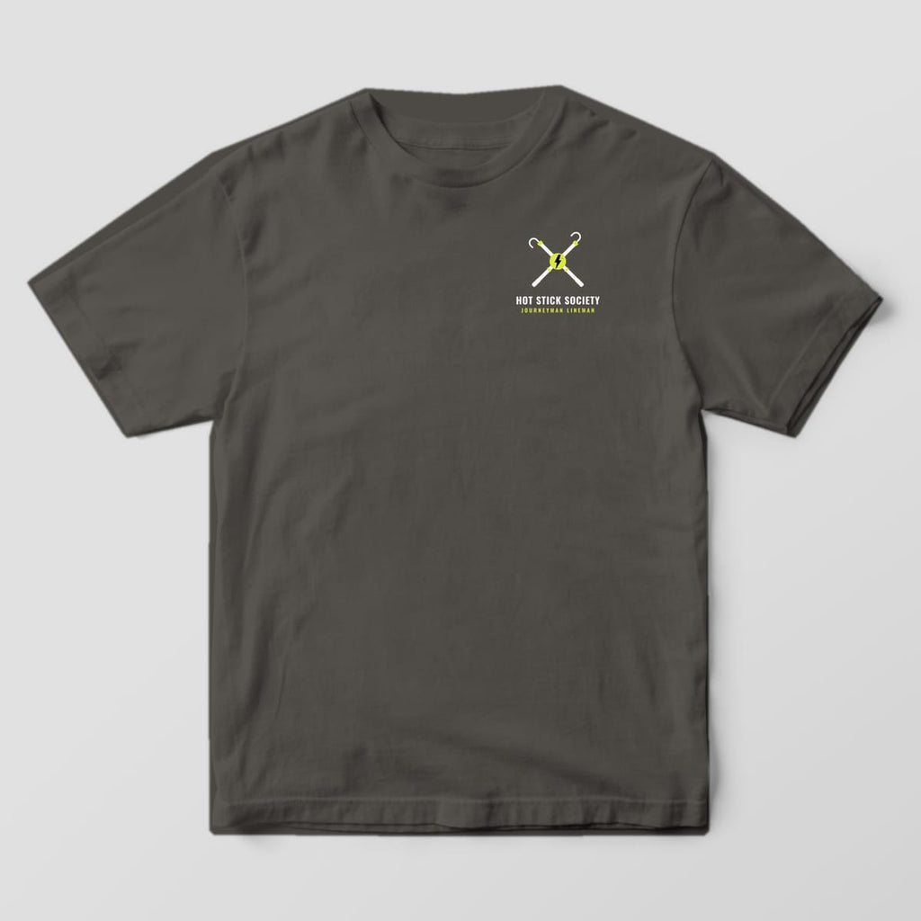 Front view of the pepper Comfort Colors 1717 shirt with the small left-chest Journeyman Lineman Crew Badge print