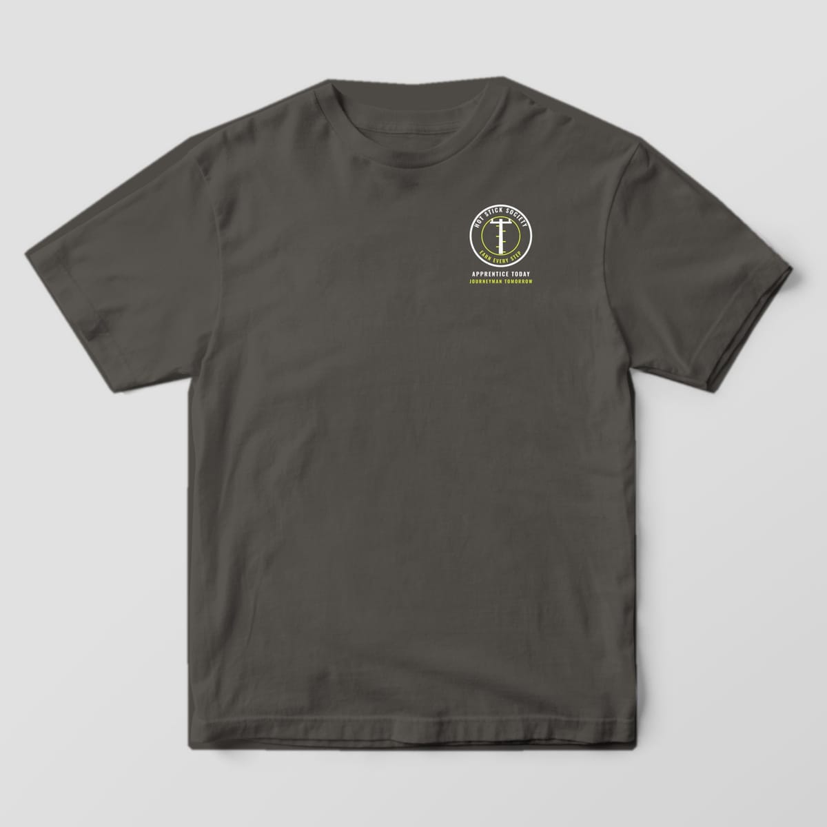 Front view of the pepper Comfort Colors 1717 shirt with the small left-chest Apprentice Today, Journeyman Tomorrow print