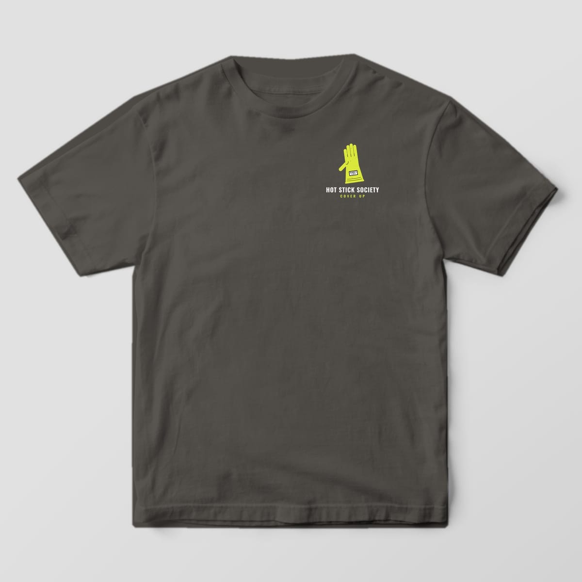 Front view of the pepper Comfort Colors 1717 shirt with the small left-chest Cover Up Rubber Goods print