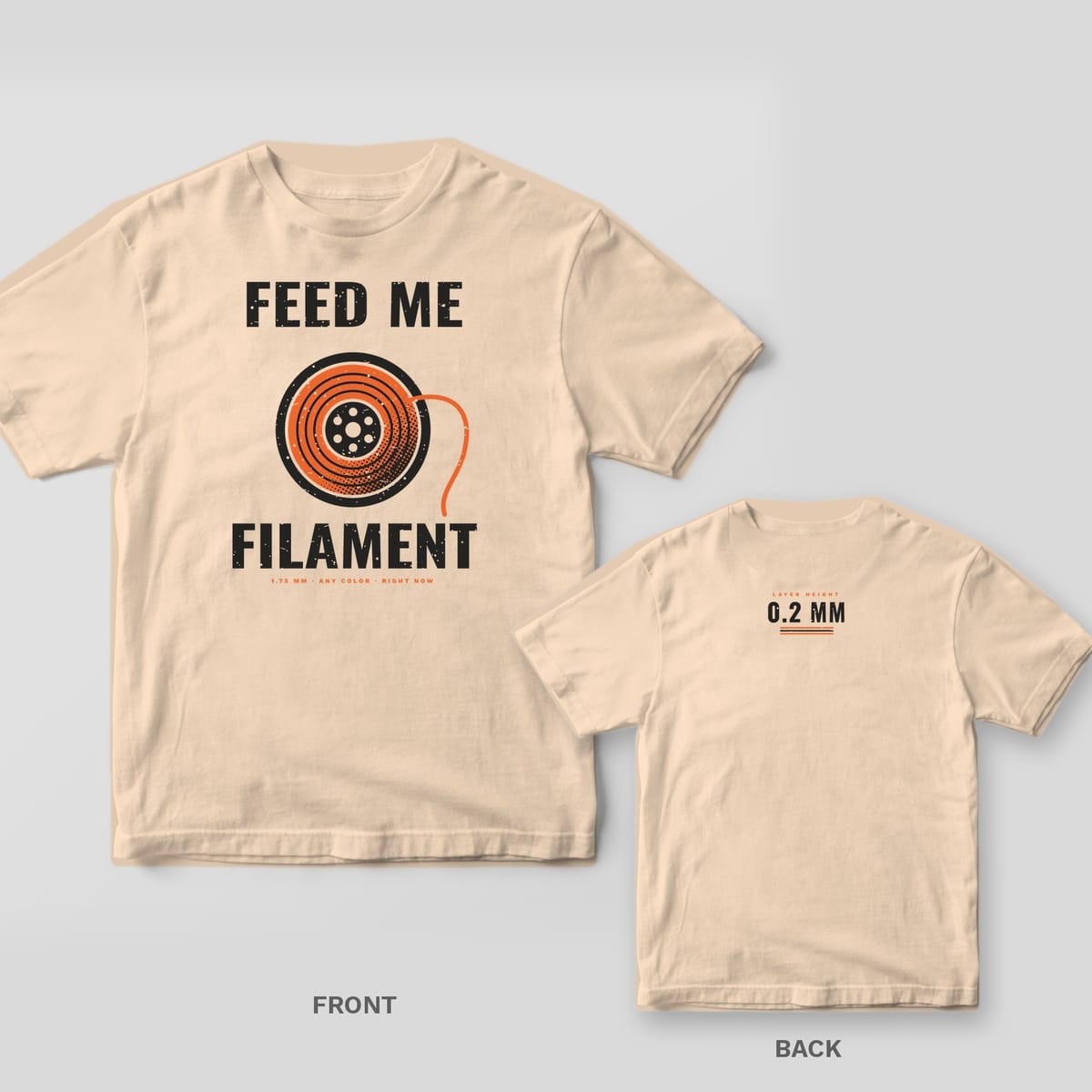 Feed Me Filament 3D printing shirt shown back and front on Ivory Comfort Colors 1717: Full-front print: "Feed Me Filament" around a large orange halftone filament spool, with "1.75 mm · Any Color · Right Now"
