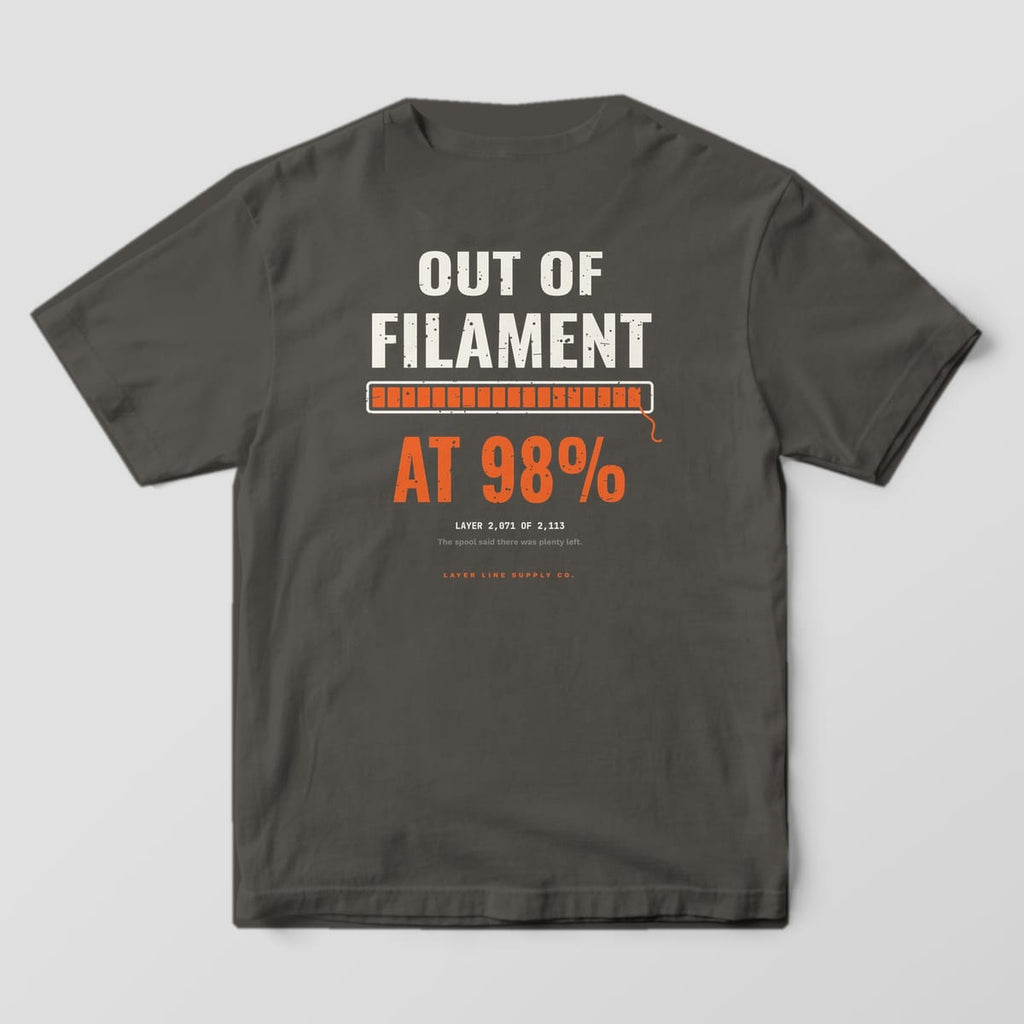 Back print on a Pepper Comfort Colors 1717 tee: "Out of Filament" over an orange progress bar stopped at 98% with a dangling filament end, "At 98%" in big orange type and "Layer 2,071 of 2,113"