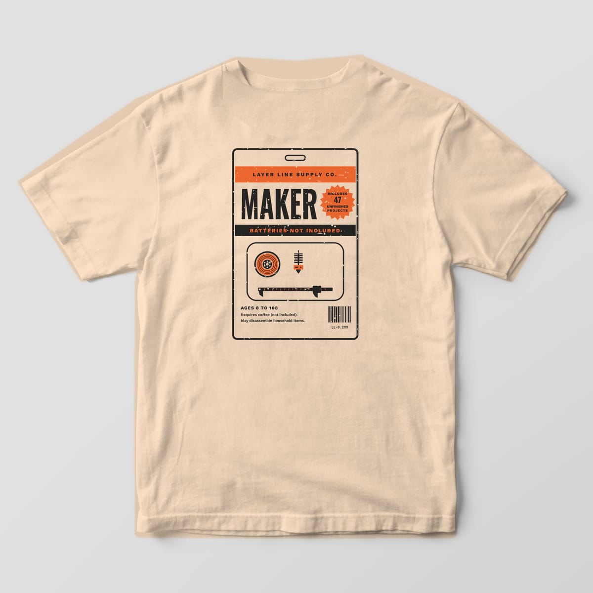 Back print on an Ivory Comfort Colors 1717 tee: Retro blister card: Layer Line Supply Co. header, big "Maker", a starburst "Includes 47 Unfinished Projects", "Batteries Not Included" band, spool, nozzle and caliper in the bubble, and a barcode