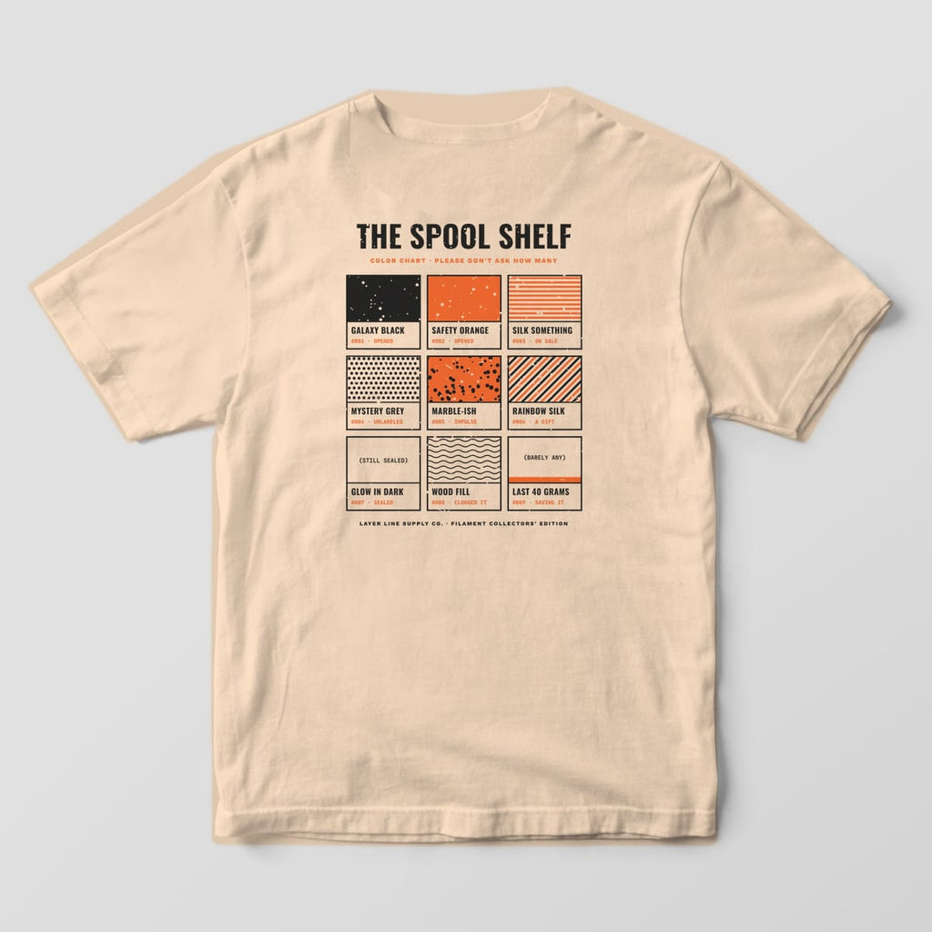 Back print on an Ivory Comfort Colors 1717 tee: "The Spool Shelf" color chart: nine paint-chip swatches in charcoal and orange patterns, each with a name, number and status like Opened, Impulse or Saving It