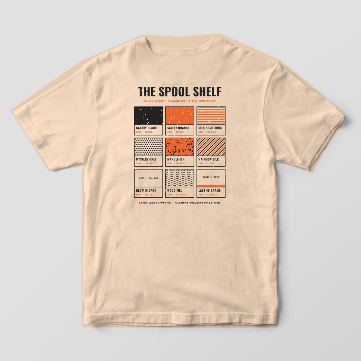 Back print on an Ivory Comfort Colors 1717 tee: "The Spool Shelf" color chart: nine paint-chip swatches in charcoal and orange patterns, each with a name, number and status like Opened, Impulse or Saving It
