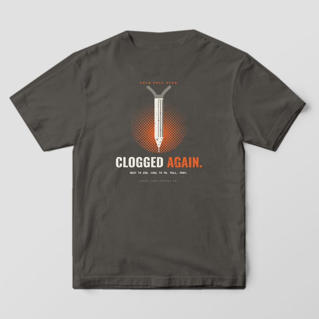 Back print on a Pepper Comfort Colors 1717 tee: "Cold Pull Club" over a pulled filament plug with a nozzle-shaped tip on an orange halftone circle, "Clogged Again." in bold and "Heat to 250. Cool to 90. Pull. Pray."