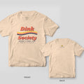 Dink Society Wave pickleball shirt shown back and front on Ivory Comfort Colors 1717: Dink Society retro wordmark with yellow, coral and navy wavy 70s stripes across the front