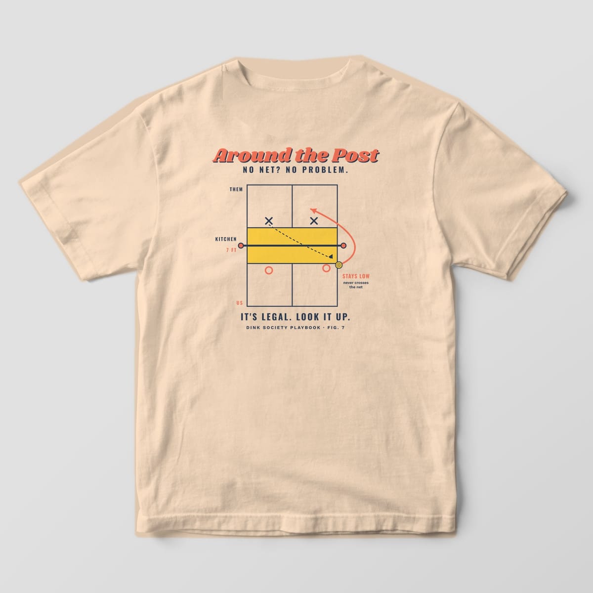 Back print on an Ivory Comfort Colors 1717 tee: Overhead pickleball court diagram with a coral arrow sending the ball around the net post