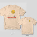 Fear the Lob pickleball shirt shown back and front on Ivory Comfort Colors 1717: Huge halftone pickleball sailing on a dotted arc over a tiny player under Fear the Lob script