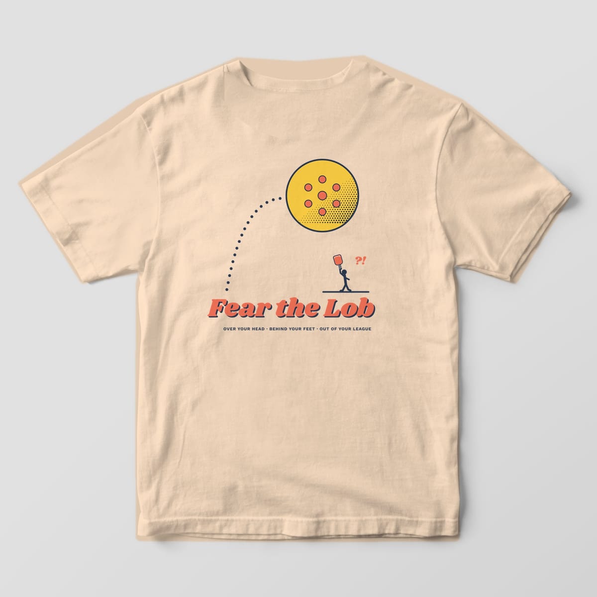 Back print on an Ivory Comfort Colors 1717 tee: Huge halftone pickleball sailing on a dotted arc over a tiny player under Fear the Lob script