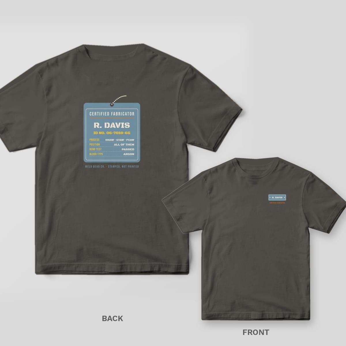 Certified Fabricator Tag (custom name) welder shirt shown back and front on Pepper Comfort Colors 1717: A hanging steel ID tag: "Certified Fabricator", the custom name, ID number and a spec list (process, position, bend test, blood type: argon)