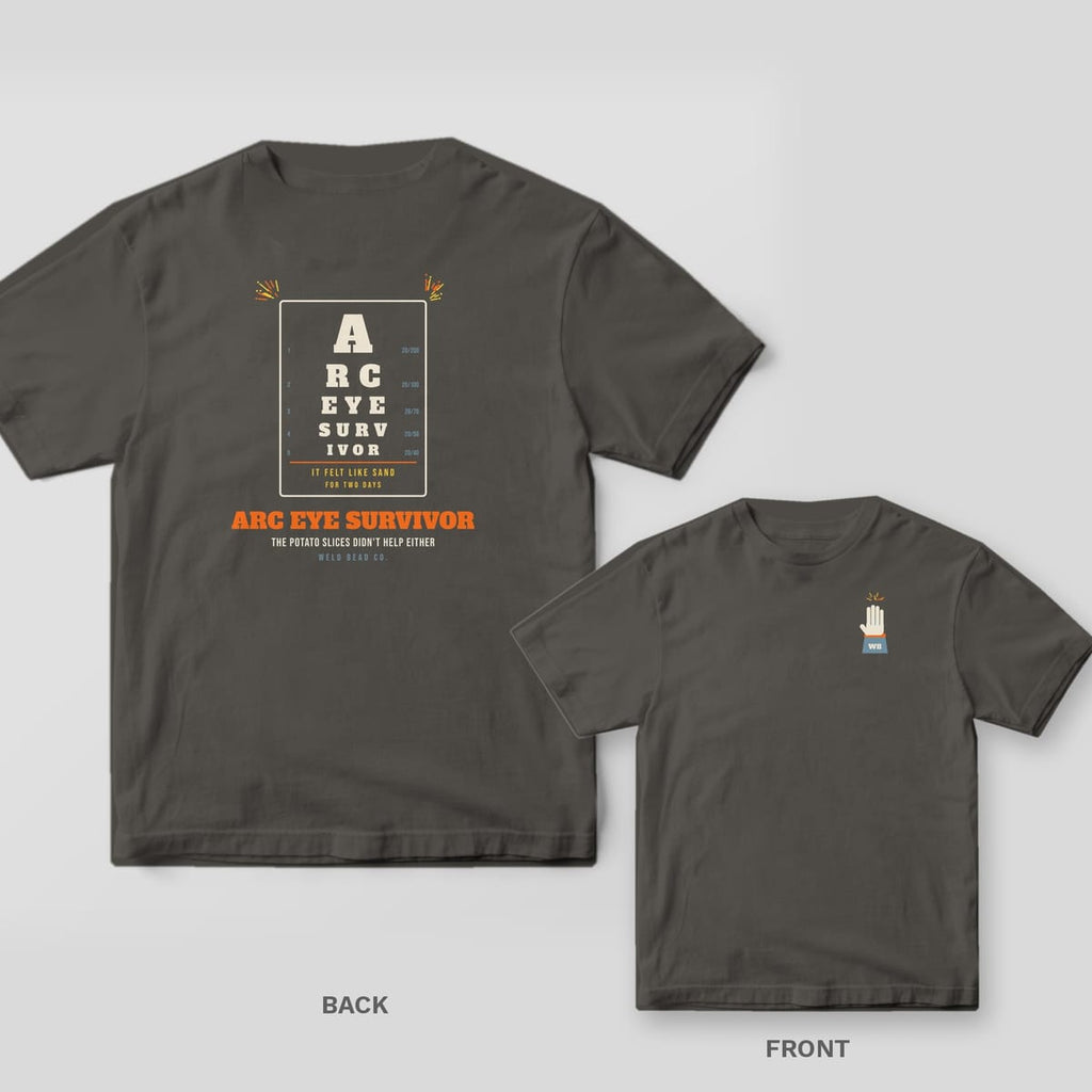 Arc Eye Survivor welder shirt shown back and front on Pepper Comfort Colors 1717: An eye chart spelling "Arc Eye Survivor" with acuity numbers, "It Felt Like Sand for Two Days" and "The Potato Slices Didn't Help Either"