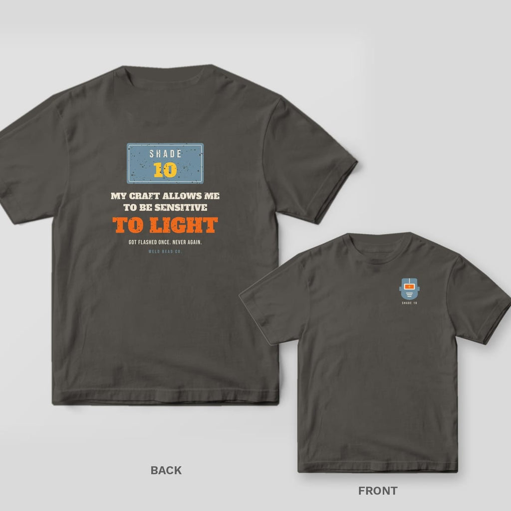 My Craft Allows Me to Be Sensitive to Light welder shirt shown back and front on Pepper Comfort Colors 1717: A Shade 10 lens plate over "My Craft Allows Me to Be Sensitive to Light" and "Got Flashed Once. Never Again."
