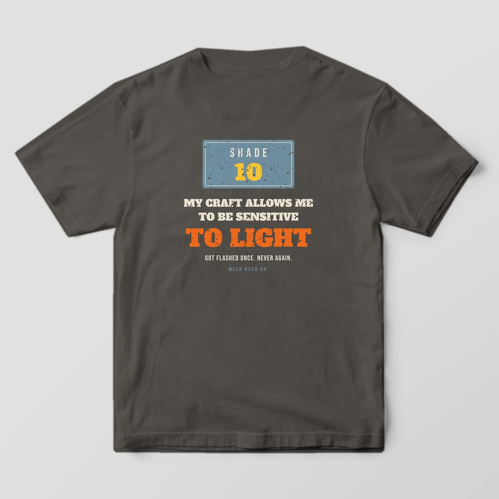 Back print on a Pepper Comfort Colors 1717 tee: A Shade 10 lens plate over "My Craft Allows Me to Be Sensitive to Light" and "Got Flashed Once. Never Again."