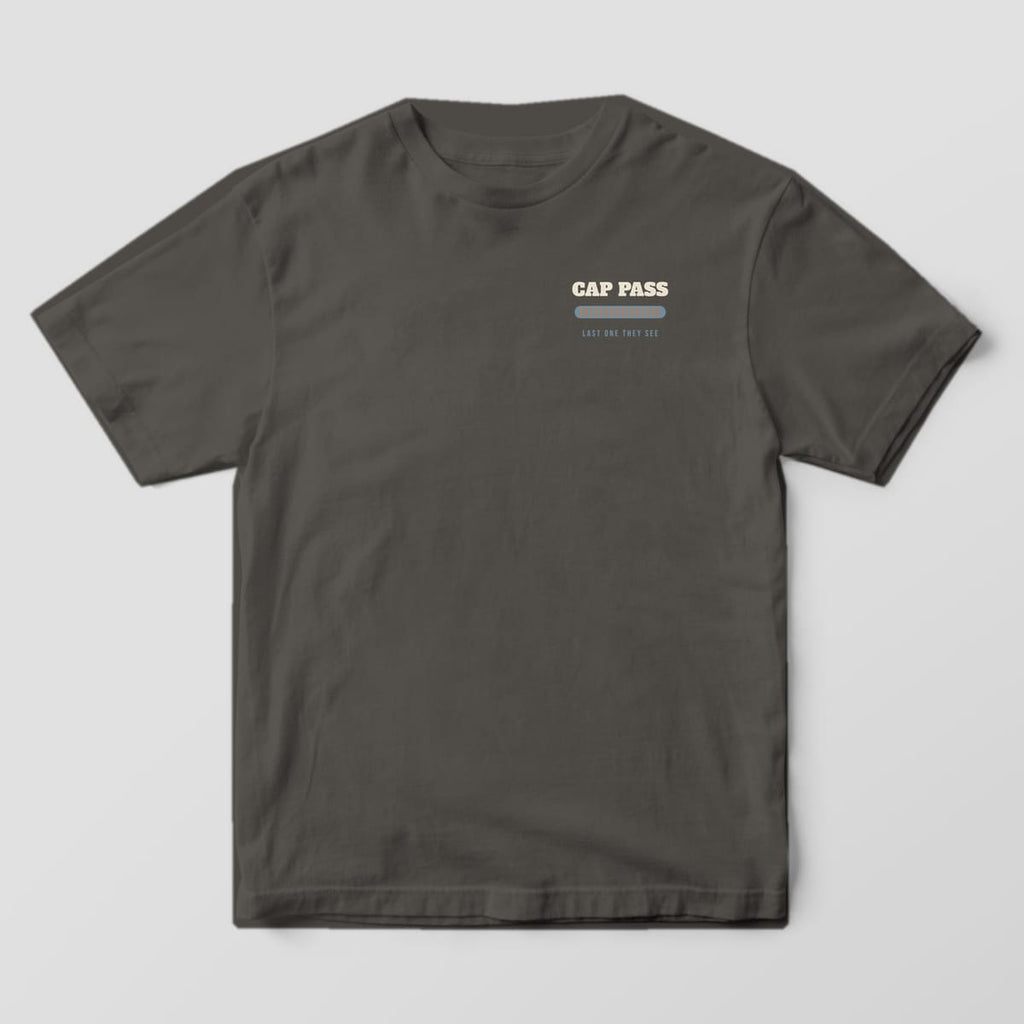 Front of the Pepper Comfort Colors 1717 tee showing the left-chest print: Left-chest "Cap Pass" over a stacked-dime bead and "Last One They See"