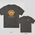 Grind Season welder shirt shown back and front on Pepper Comfort Colors 1717: Arched "Grind Season" over a flap disc drawn as a striped retro sunset, with "Open All Year · 40 to 120 Grit"