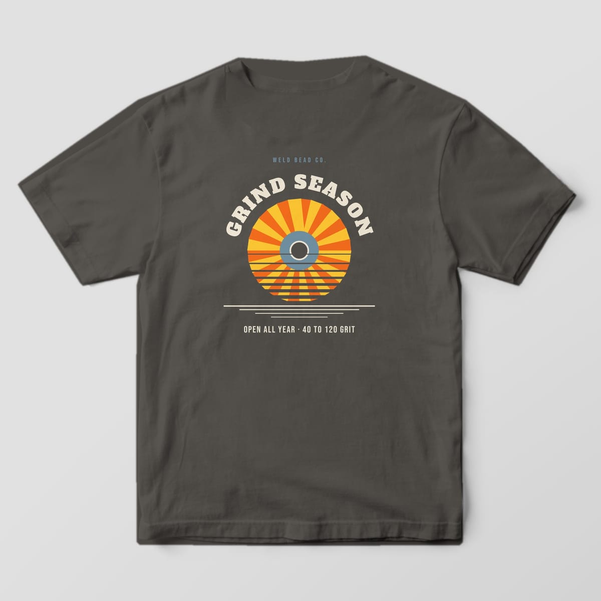 Back print on a Pepper Comfort Colors 1717 tee: Arched "Grind Season" over a flap disc drawn as a striped retro sunset, with "Open All Year · 40 to 120 Grit"