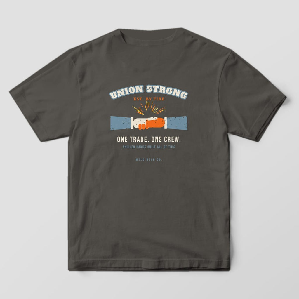 Back print on a Pepper Comfort Colors 1717 tee: Arched "Union Strong" over a gloved handshake with sparks, "One Trade. One Crew." and "Skilled Hands Built All of This"