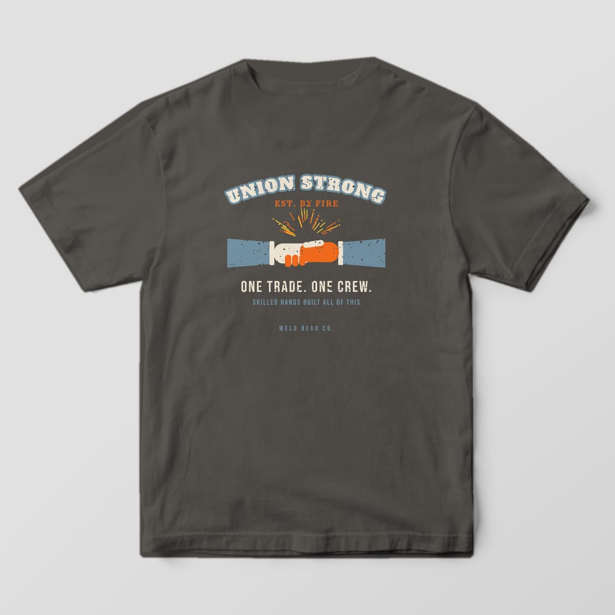 Back print on a Pepper Comfort Colors 1717 tee: Arched "Union Strong" over a gloved handshake with sparks, "One Trade. One Crew." and "Skilled Hands Built All of This"