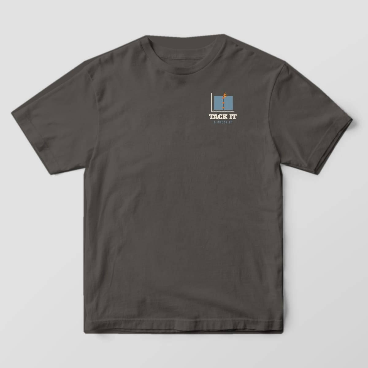 Front of the Pepper Comfort Colors 1717 tee showing the left-chest print: Small left-chest butt joint with three orange tacks against a framing square, with "Tack It & Check It"