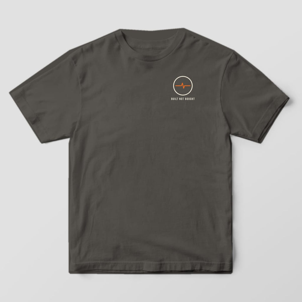 Front of the Pepper Comfort Colors 1717 tee showing the left-chest print: Small left-chest round arc symbol with "Built Not Bought"