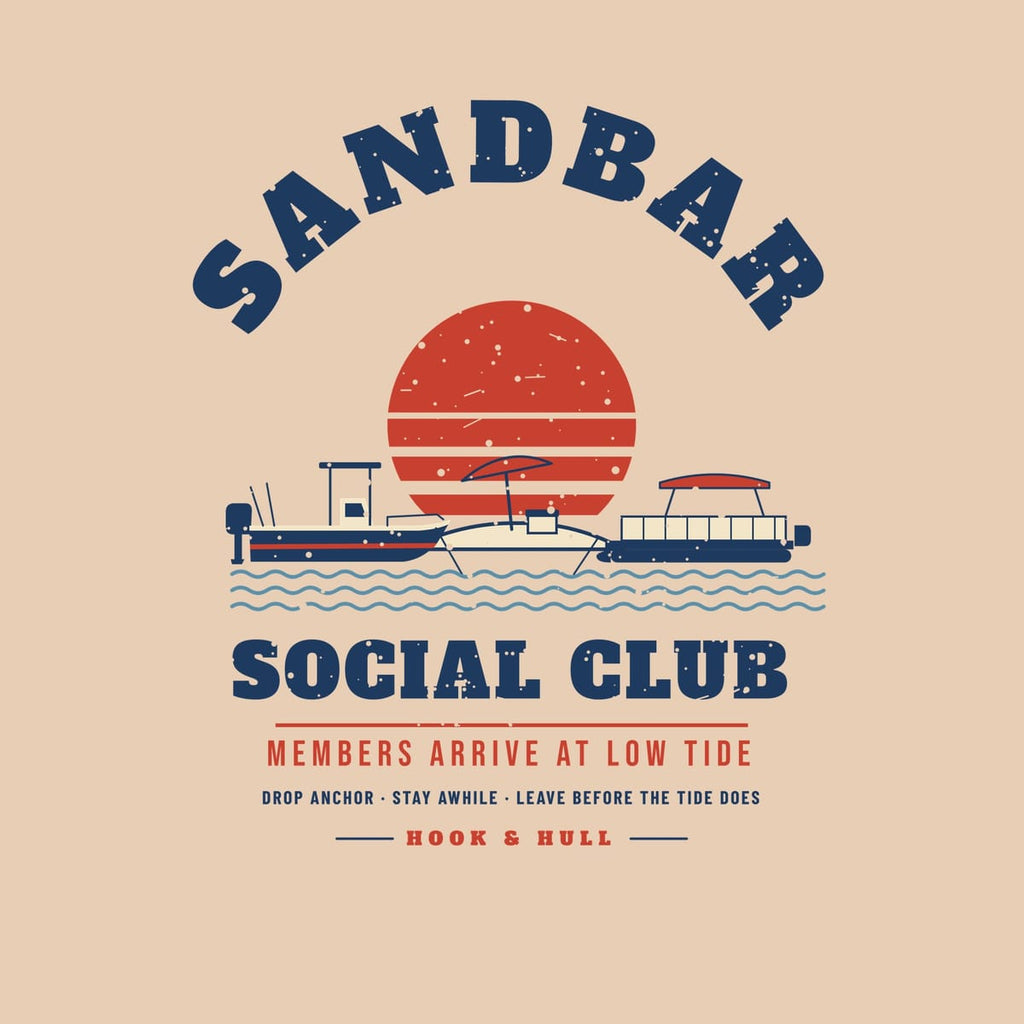 Close-up of the print artwork on an ivory background: full front print of two anchored boats at a sandbar under a striped sunset with the words Sandbar Social Club