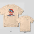 Back and front of an ivory Comfort Colors T-shirt with a retro sunset with a leaping fish on a fishing line, a small boat and the words Reel Therapy; small chest print on the front