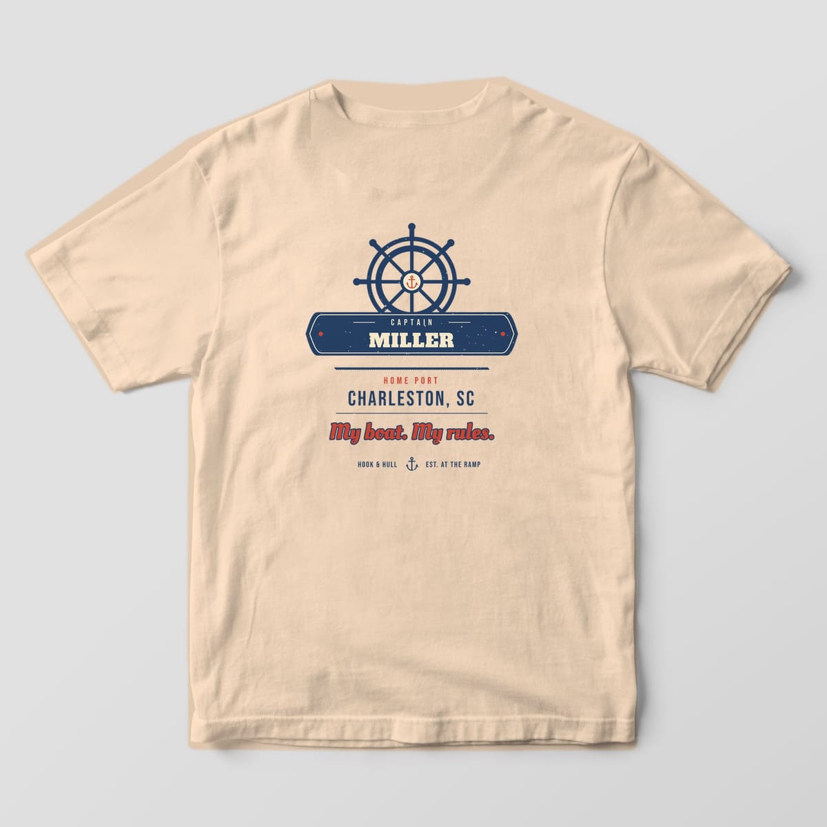 Back of an ivory Comfort Colors 1717 T-shirt showing a ship's wheel over a navy nameplate reading Captain Miller, home port Charleston SC and the line My boat. My rules