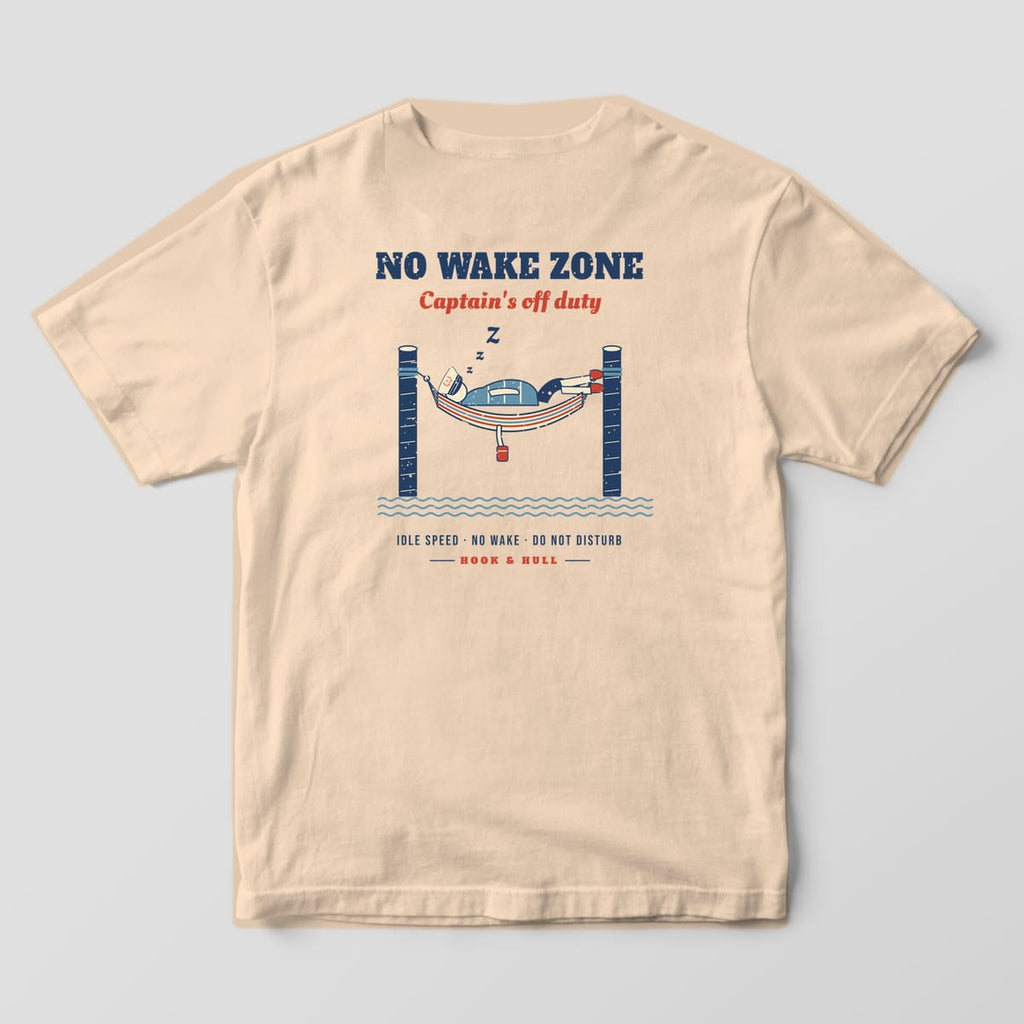 Back of an ivory Comfort Colors 1717 T-shirt showing the captain napping in a striped hammock between two dock pilings under the words No Wake Zone, Captain's off duty