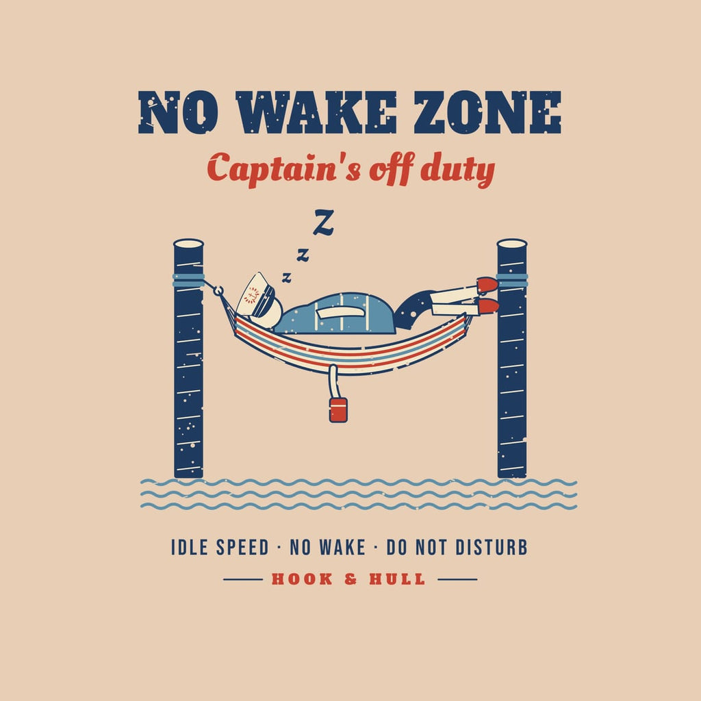 Close-up of the back print artwork on an ivory background: captain napping in a striped hammock between two dock pilings under the words No Wake Zone, Captain's off duty