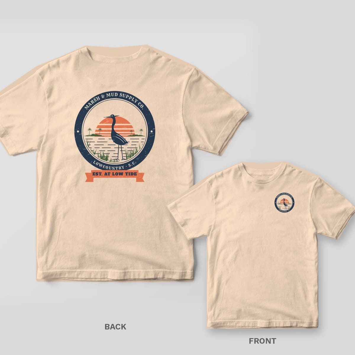 Back and front of an ivory Comfort Colors tee with a navy round heron badge and coral sunset