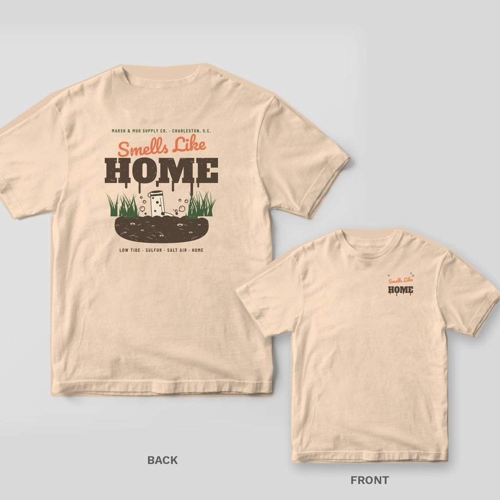 Back and front of an ivory Comfort Colors tee with Smells Like Home lettering and a boot stuck in marsh mud