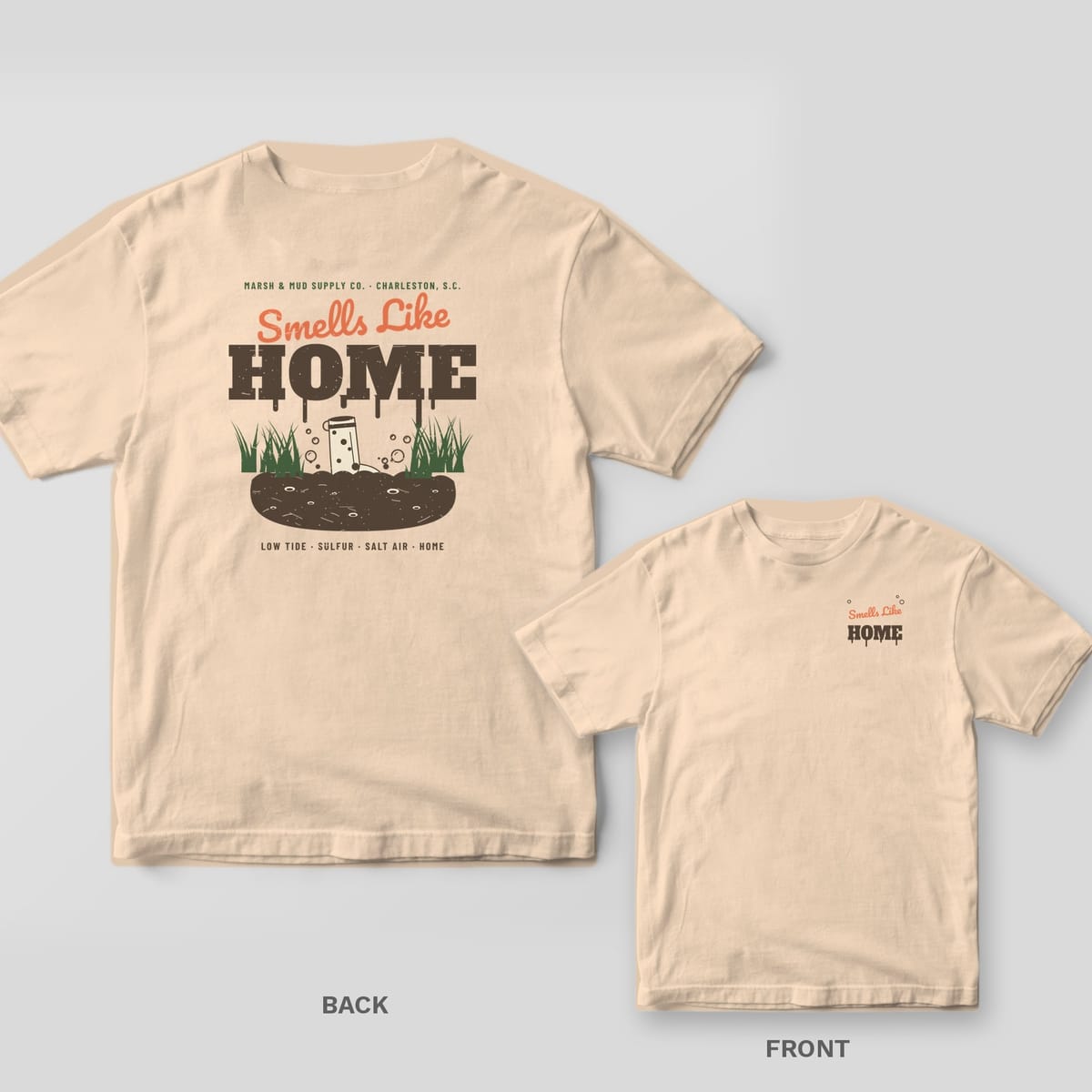 Back and front of an ivory Comfort Colors tee with Smells Like Home lettering and a boot stuck in marsh mud