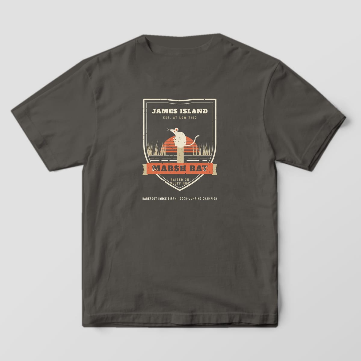 Back of a pepper Comfort Colors 1717 tee with a cream shield badge, marsh rat on a piling and coral Marsh Rat ribbon