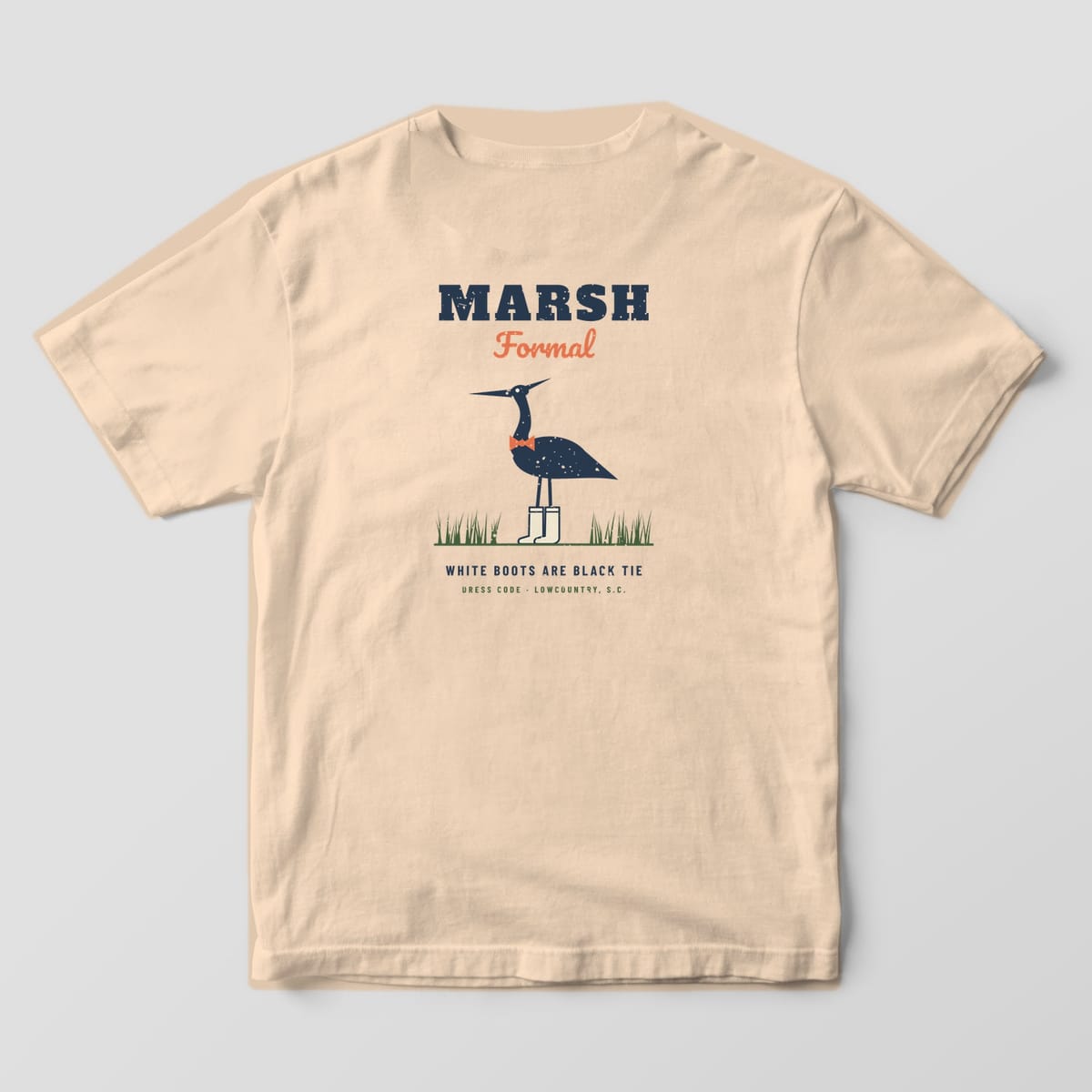 Back of an ivory Comfort Colors 1717 tee with Marsh Formal lettering and a heron in white boots