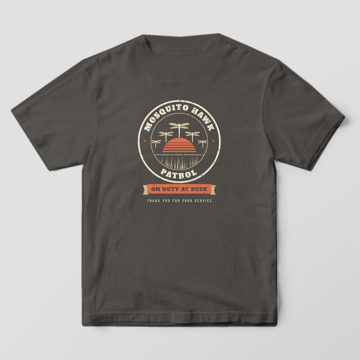 Back of a pepper Comfort Colors 1717 tee with a cream patrol badge, dragonflies and coral sunset