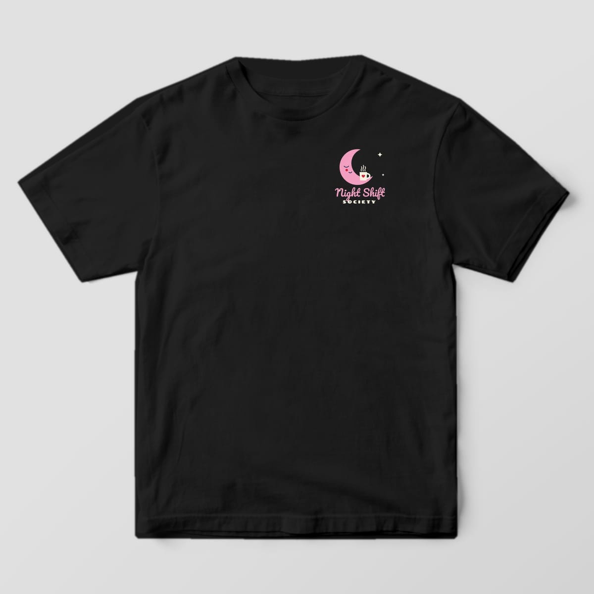 Front of a black Comfort Colors 1717 tee with a small pink moon and Night Shift Society on the left chest