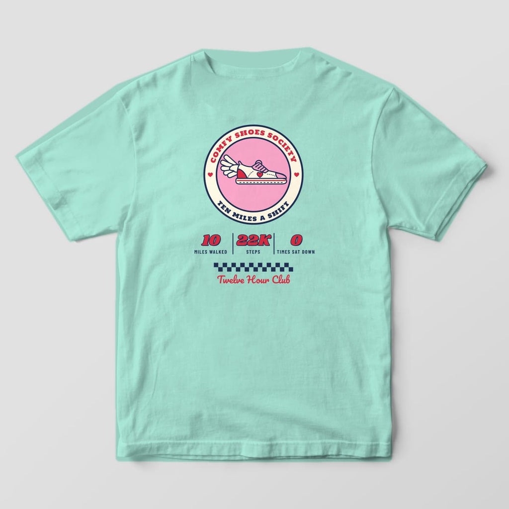 Back of a chalky mint Comfort Colors 1717 tee with a round Comfy Shoes Society badge, winged sneaker and shift stats