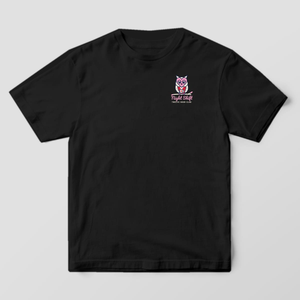 Front of a black Comfort Colors 1717 tee with a small owl and Night Shift script on the left chest