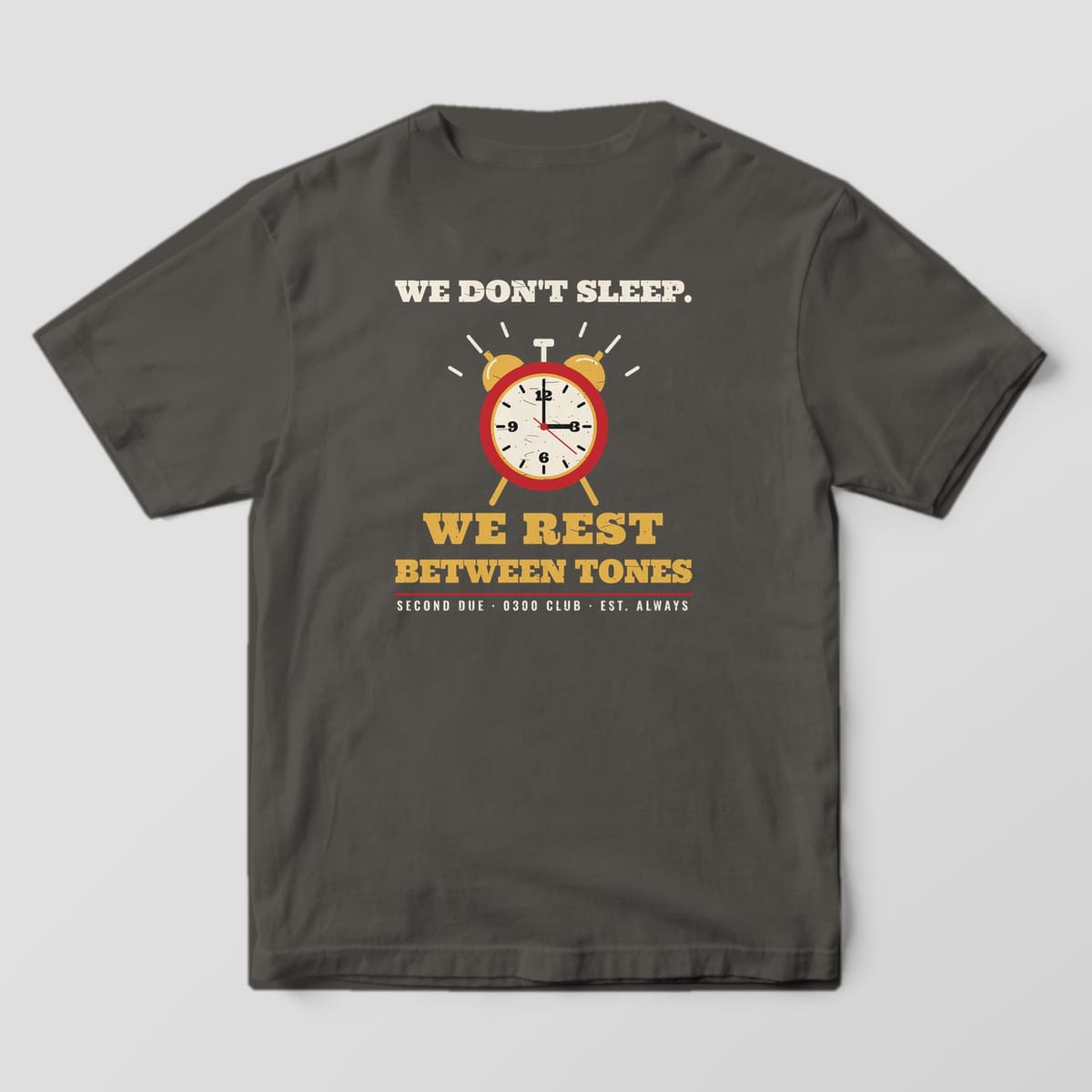 Back of a pepper Comfort Colors tee with an alarm clock at 0300 and the text We Don't Sleep, We Rest Between Tones