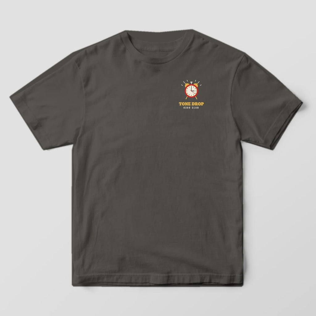 Front of a pepper Comfort Colors tee with a small alarm clock and Tone Drop 0300 Club on the left chest