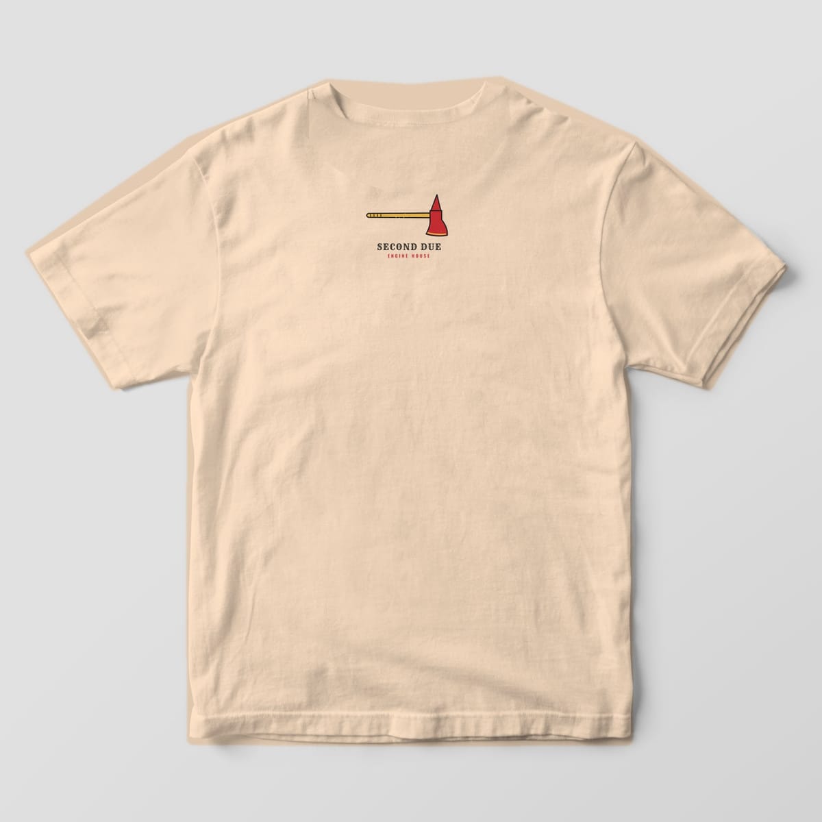 Upper back of an ivory Comfort Colors tee with a small red fire axe and Second Due Engine House text